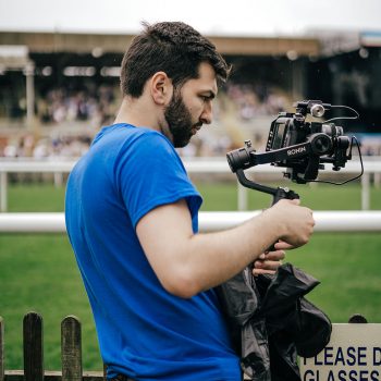 Man filming horse racing