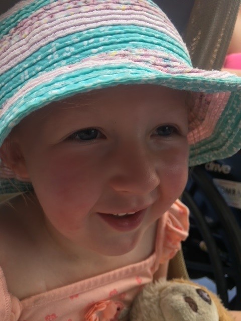 Grace smiling wearing a sunhat, closeup image