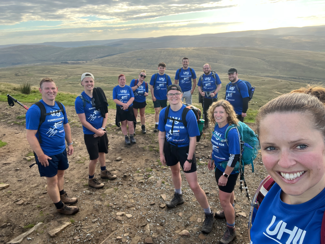 The team at the top of one of the three peaks in blue t-shirts